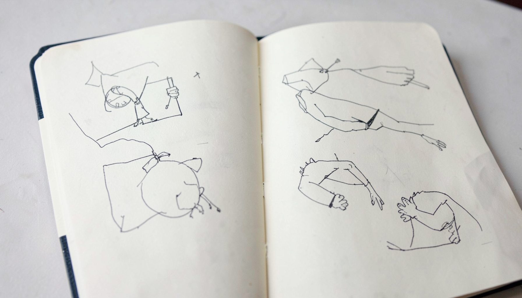 An open notebook page with simple sketched diagrams in dark ink on off-white paper, calm and thoughtful in tone